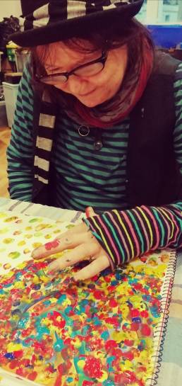A client painting a colourful picture during an art therapy session.