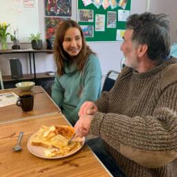 Genesis staff member eating with a homeless man.