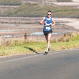 Man running alone in the Scottish countryside.