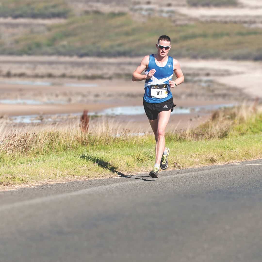 Man running alone in the Scottish countryside.