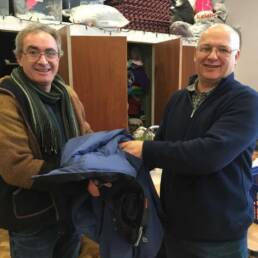 Man receiving a winter jacket from a Genesis staff member.