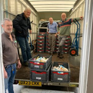 Volunteers with John Stauber unloading crates of food into the new warehouse 