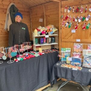 A Genesis team member standing inside the market stall