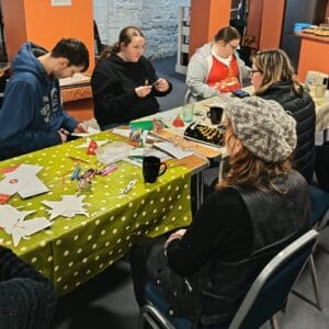 People sitting at a table doing Christmas crafts