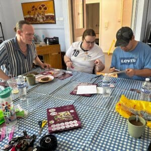 Guestsof Genesis Trust working on art at a table.
